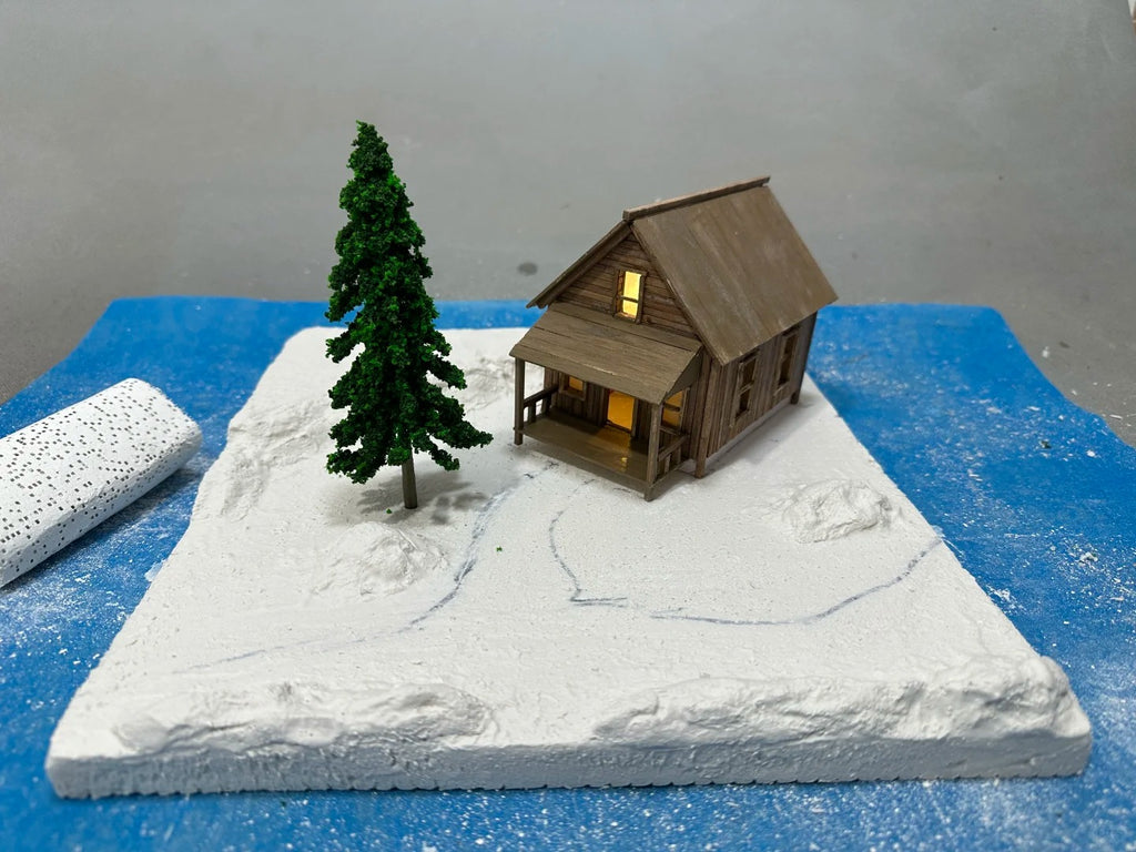 A 1:64 scale miniature scene of a log cabin in the snow