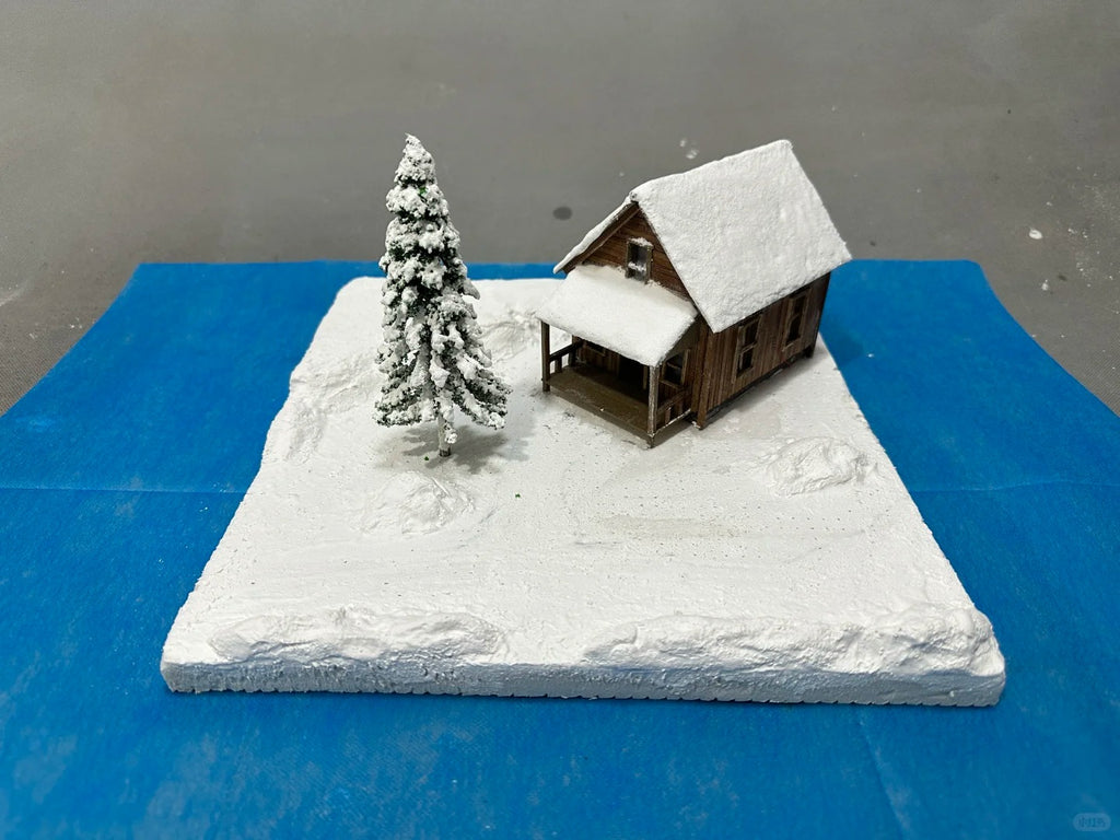 A 1:64 scale miniature scene of a log cabin in the snow