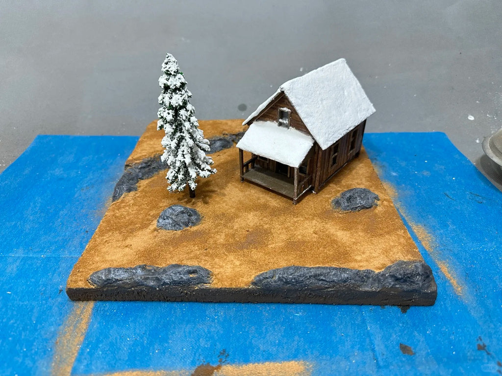 A 1:64 scale miniature scene of a log cabin in the snow