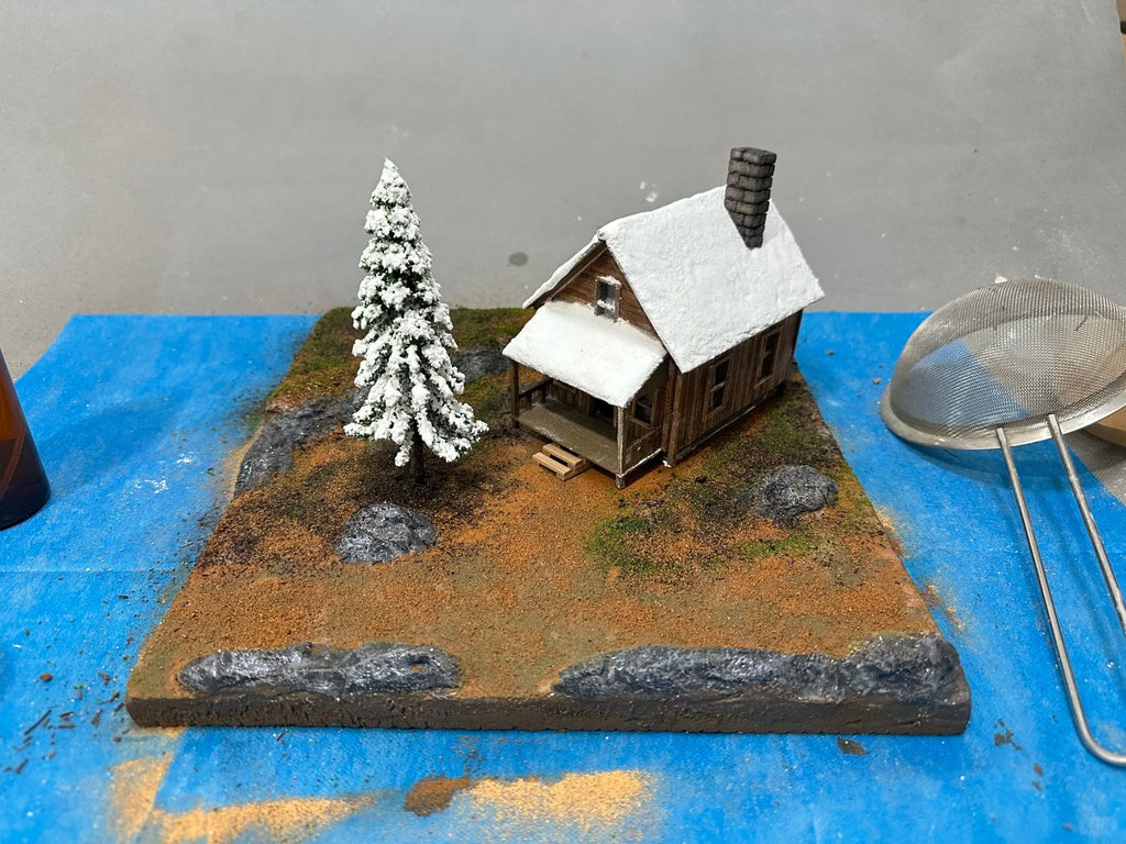A 1:64 scale miniature scene of a log cabin in the snow