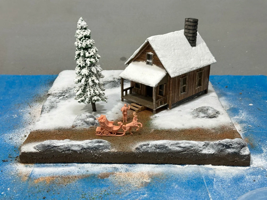 A 1:64 scale miniature scene of a log cabin in the snow